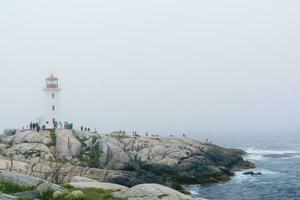 de peggy ensenada, Canadá - agosto 13, 2015-personas cerca el de peggy ensenada faro en estrella nueva Escocia-Canadá durante un brumoso día foto