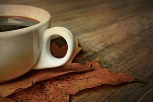 hot autumn black espresso coffee on a wooden table and autumn maple leaves photo