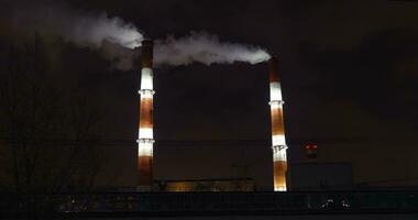 Passenger train passing by factory at night video