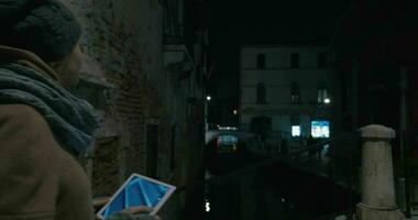 mujer con almohadilla tomando disparos de Venecia canal a noche video