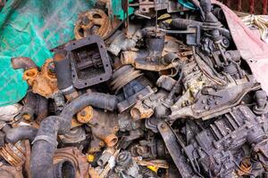 Pile of rusty and dirty obsoleted old vehicle metal engine and spare parts. photo