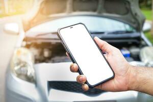 male hand holding a black smartphone with a white touch screen Call an insurance company or a mechanic for help. Because he had an accident or the car engine broke down. car insurance photo