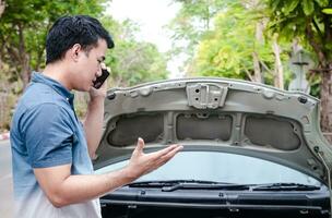 man holding a black smartphone Call an insurance company or a mechanic for help. Because he had an accident or the car engine broke down. concept of car insurance, communication technology photo