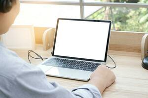 Close-up view of a laptop computer with a white screen. man working from home Sit and work for an online meeting via video call. Concept of social distancing during the coronavirus pandemic photo