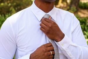 novio consiguiendo Listo para su Boda y apretar su Corbata foto