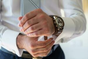 groom getting ready for his wedding. Detail of your watch photo