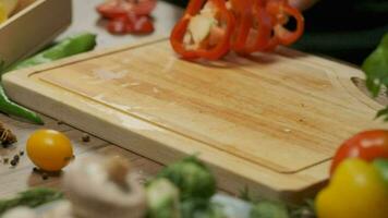 Professional chef prepares and cuts red bell pepper. Close up slow motion video