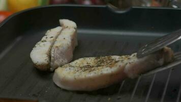 fechar acima profissional chefe de cozinha grelhar branco peixe filé bife. lento movimento video