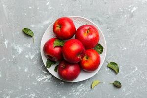 Many red apples on cement background, top view. Autumn pattern with fresh apple above view photo