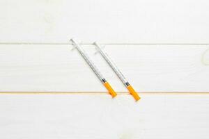 Top view of insulin syringe prepared for injection at wooden background. Diabetes concept with copy space photo