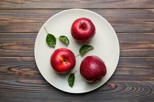 jugoso rojo manzanas en un cuenco o plato en el mesa parte superior vista. Copiar espacio foto