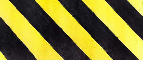 Safety stripes on construction site, Black and yellow Under construction sign over a grunge texture, top view photo