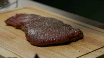 Professional chef peppers meat fillet steak from hand pepper mill, close up slow motion. video