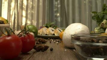 Fresh vegetables in the box on the kitchen table camera close-up. Bottles with vinegar and oil and pepper shaker mill on the back video