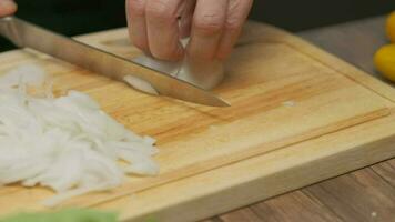 professionnel chef prépare et coupes blanc oignon. proche en haut lent mouvement video