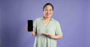 Gangang middle-aged Asian female portrait posing on purple background photo