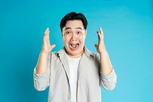 Portrait of an Asian guy posing on a blue background photo