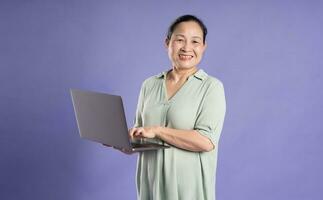 Gangang middle-aged Asian female portrait posing on purple background photo