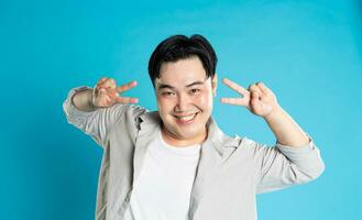 Portrait of an Asian guy posing on a blue background photo