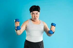 Image of Asian man exercising on blue background photo