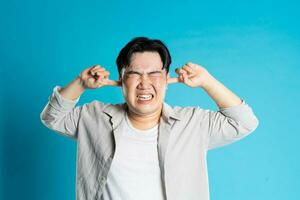 Image of Asian man having health problems, isolated on blue background photo