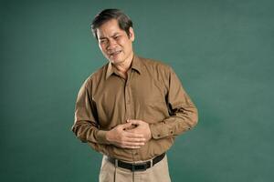 retrato de medio Envejecido asiático hombre posando en azul antecedentes foto