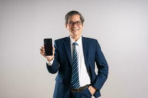 Portrait of an elderly Asian businessman, posing on a blue background photo