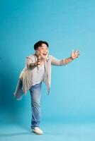 Full body image of Asian man posing on blue background photo