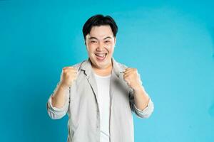 Portrait of an Asian guy posing on a blue background photo