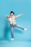 Full body image of Asian man posing on blue background photo