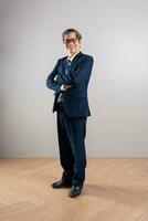 retrato de un mayor asiático empresario, posando en un azul antecedentes foto