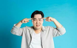 Image of Asian man having health problems, isolated on blue background photo
