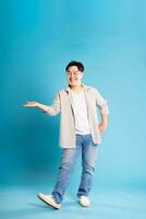 Full body image of Asian man posing on blue background photo