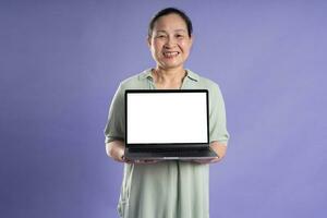 Gangang middle-aged Asian female portrait posing on purple background photo