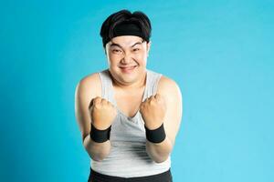 Image of Asian man exercising on blue background photo