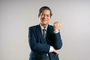 Portrait of an elderly Asian businessman, posing on a blue background photo