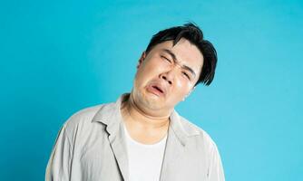 Portrait of an Asian guy posing on a blue background photo