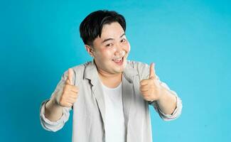 Portrait of an Asian guy posing on a blue background photo