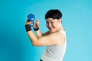 Image of Asian man exercising on blue background photo