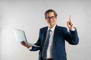 Portrait of an elderly Asian businessman, posing on a blue background photo