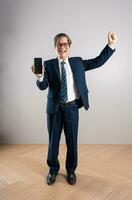 Portrait of an elderly Asian businessman, posing on a blue background photo