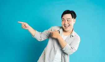 Portrait of an Asian guy posing on a blue background photo