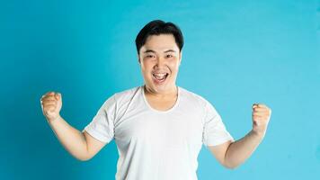 Portrait of an Asian guy posing on a blue background photo