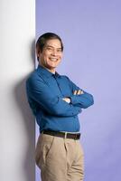 portrait of middle aged asian business man posing on purple background photo