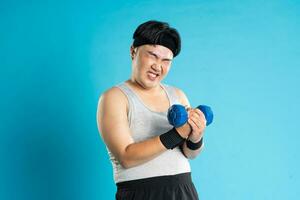 Image of Asian man exercising on blue background photo