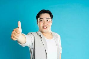 Portrait of an Asian guy posing on a blue background photo