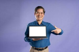 portrait of middle aged asian business man posing on purple background photo