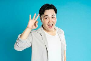 Portrait of an Asian guy posing on a blue background photo