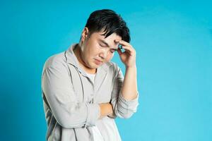 Image of Asian man having health problems, isolated on blue background photo