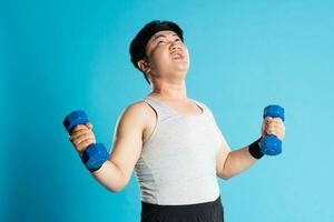 Image of Asian man exercising on blue background photo